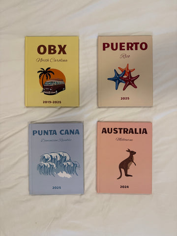 Four travel photobooks with different destinations on a light background