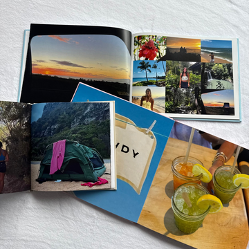 Open photo album with scenic and casual photos on a textured white surface