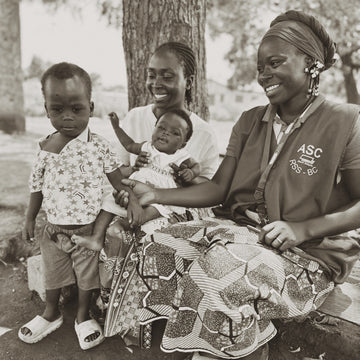Woman with children outdoors, wearing a vest