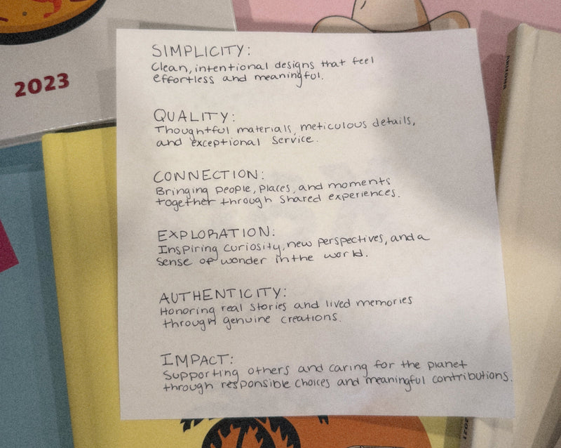 our values written on a white sheet of paper over colorful books