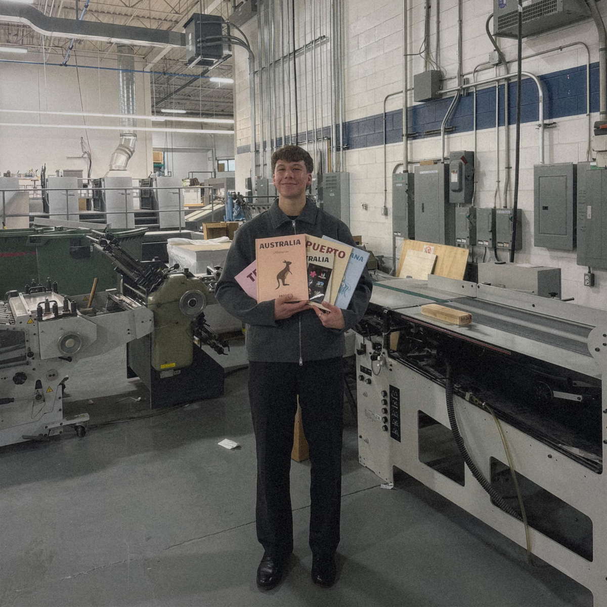 Person holding books in a printing factory setting