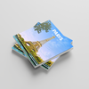 A stack of Paris travel photobooks featuring the Eiffel Tower under a blue sky, with the word 'PARIS' printed on the top card, set against a light gray background.