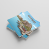 Two square photobooks stacked on a light gray background. The top coaster features an illustration of a Norwegian landscape with a red houses and a blue sky and rocky mountains, with the word 'NORWAY' printed on it.