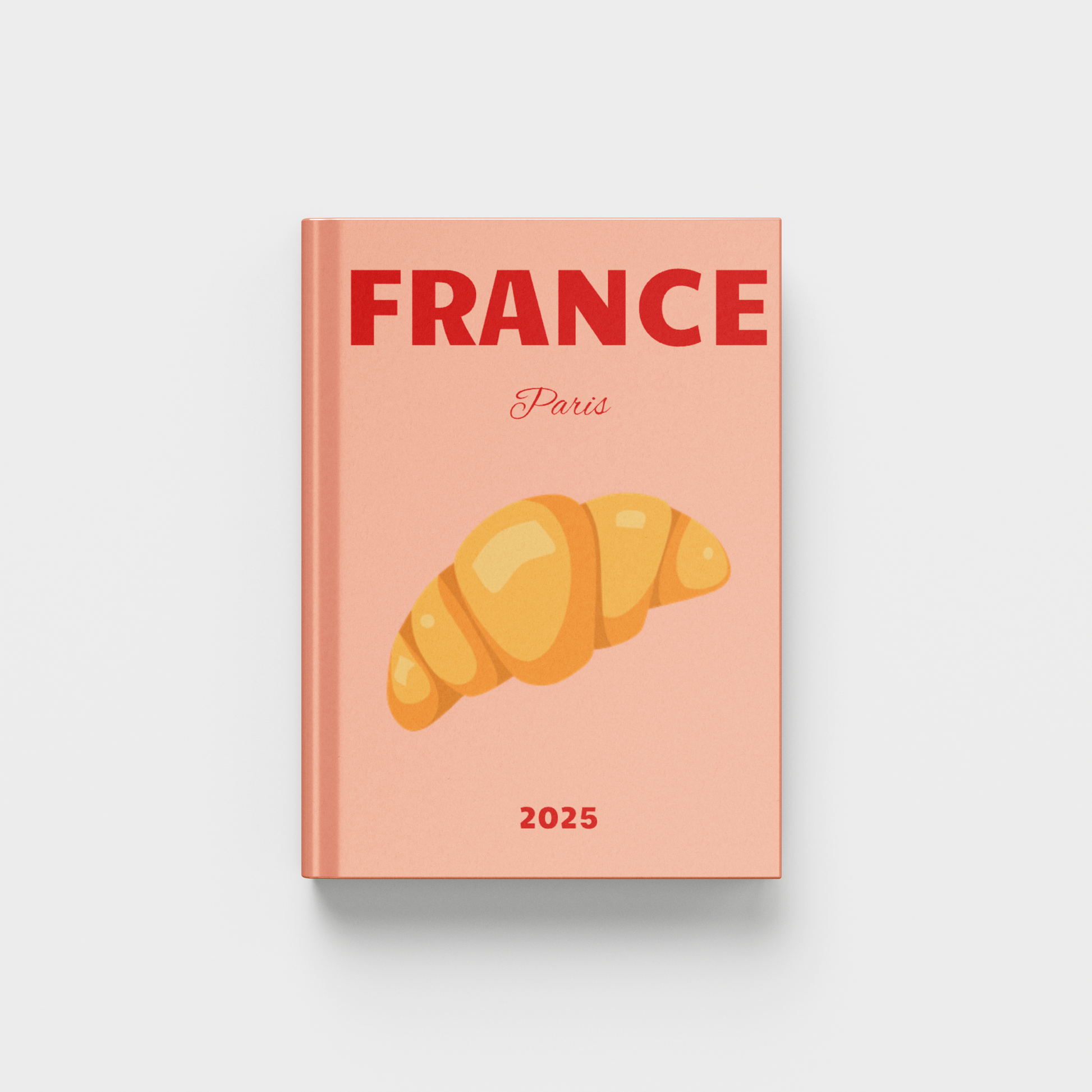 photobook with 'France Paris 2025' on a peach cover featuring a croissant illustration.
