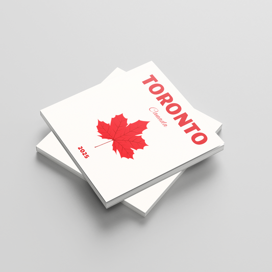 Stack of square photobooks with a red maple leaf and 'Toronto' text on a gray background