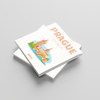Stack of square photobooks with 'Prague' on the cover on a gray background