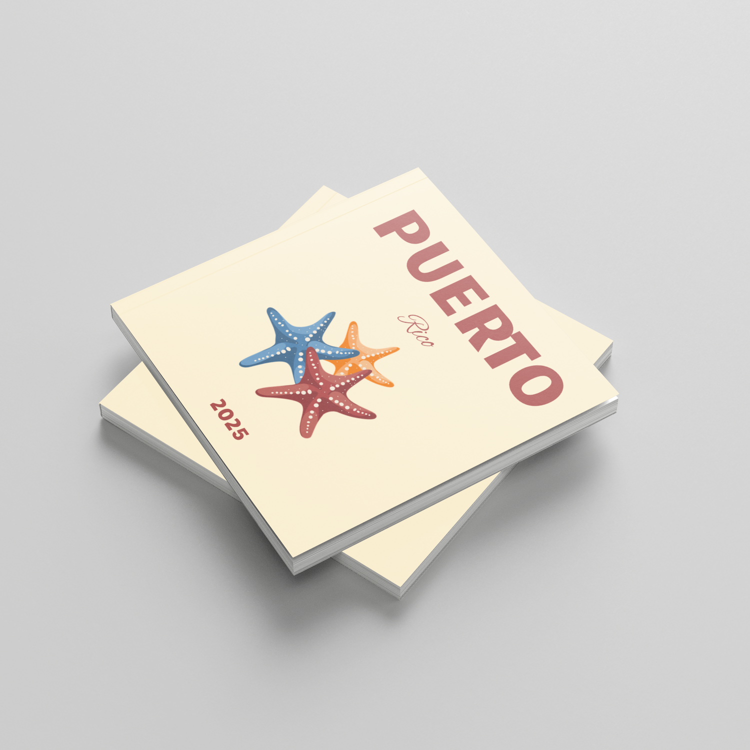 Stack of square photobooks with 'PUERTO RICO' and starfish design on a gray background