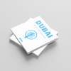Stack of white Dubai photobooks with blue text and logo on a gray background