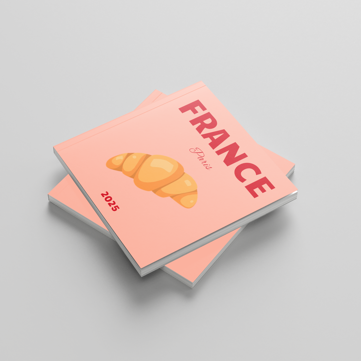 Two pink square photobooks with a croissant illustration and 'France' text on a gray background