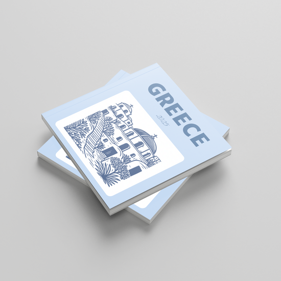 Stack of photobooks with 'Greece' and architectural illustration on a light gray background