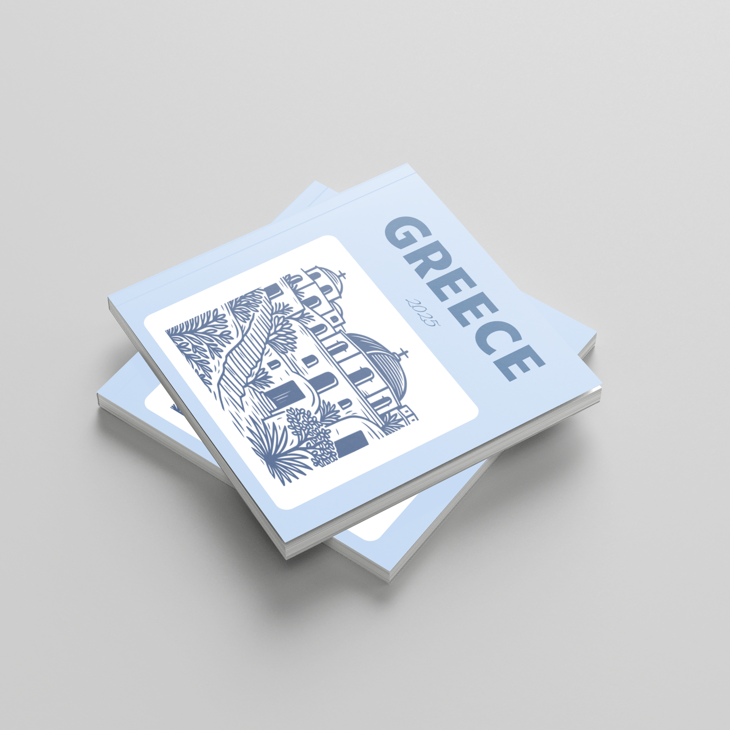 Stack of photobooks with 'Greece' and architectural illustration on a light gray background