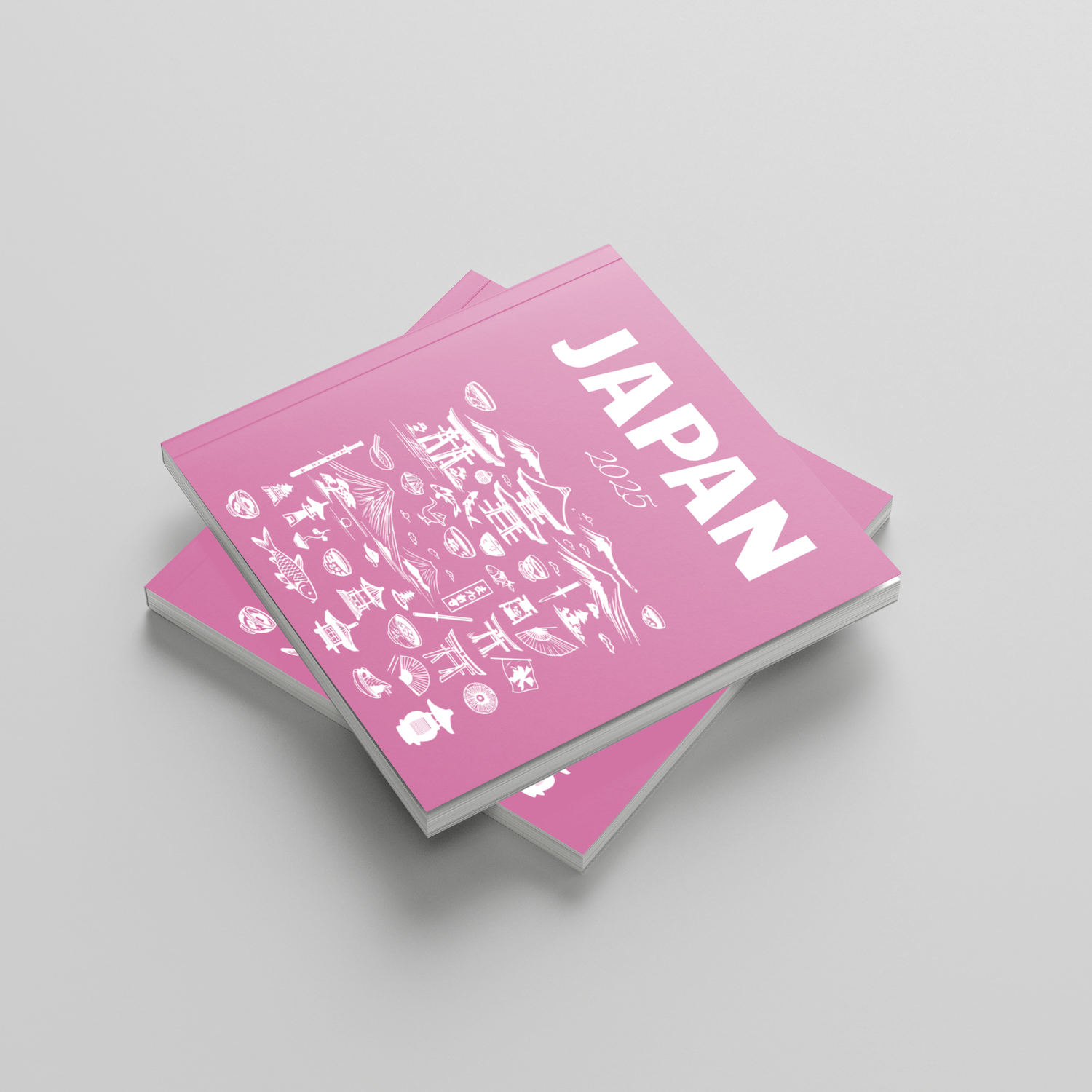 Two pink books with Japanese text and 'JAPAN' printed on a gray background